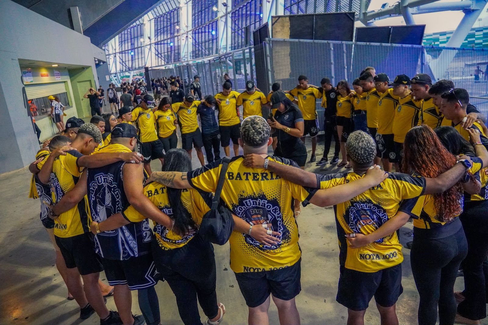 Integrantes da Bateria Nota 1000 abraçados em roda antes do jogo